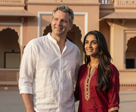 Daniel from Florida and Priya from India standing together in front of Indian architecture after successful matchmaking