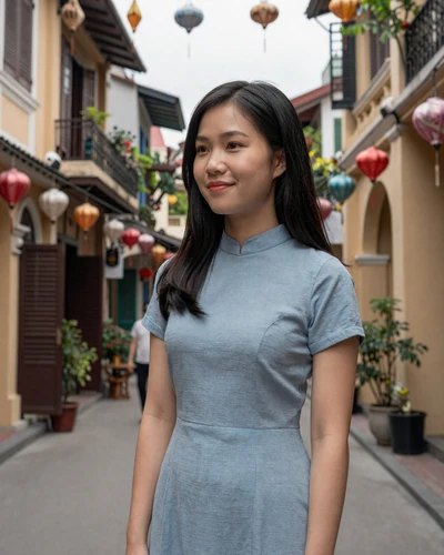 Hien, 25, Vietnamese woman from Hanoi in a blue dress on Old Quarter street