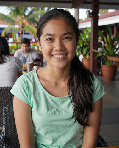 April, 23, Filipino woman laughing at an outdoor Davao restaurant